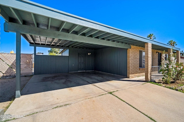 view of car parking featuring fence and a carport