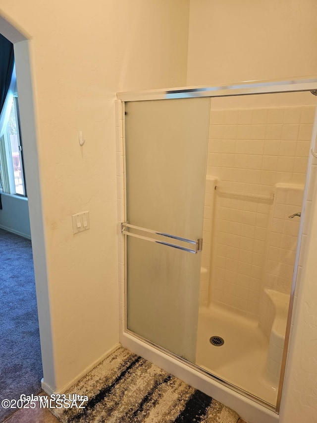 bathroom featuring baseboards and a shower stall