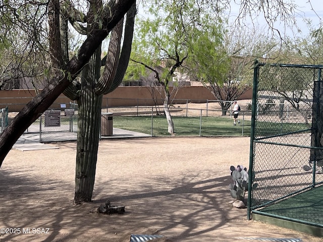 view of tennis court with a gate and fence