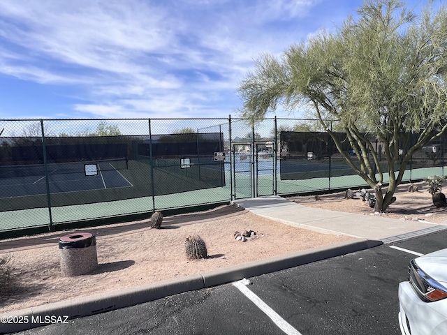 view of tennis court with a gate and fence
