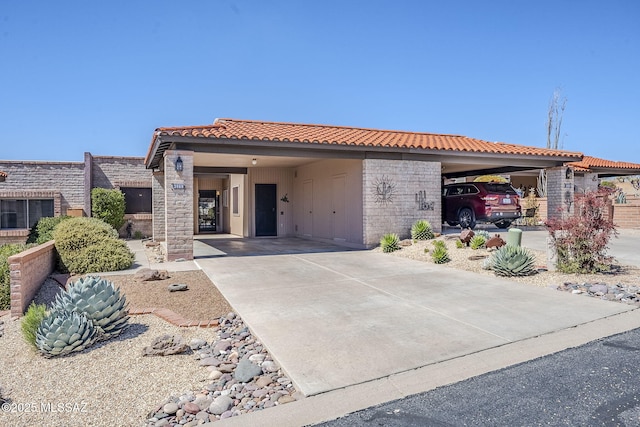view of front of house with a carport, concrete driveway, and a tile roof