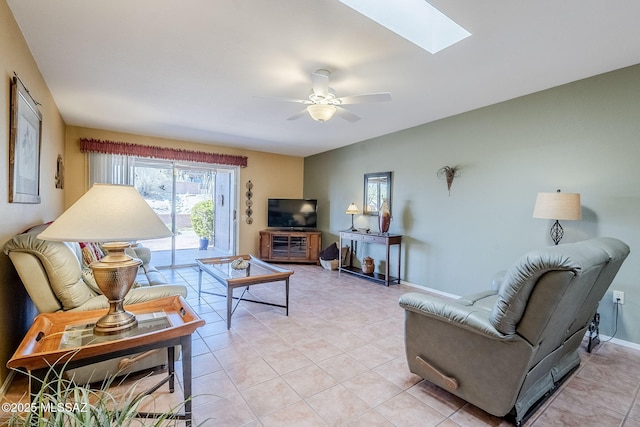 living room with light tile patterned floors, baseboards, a skylight, and a ceiling fan