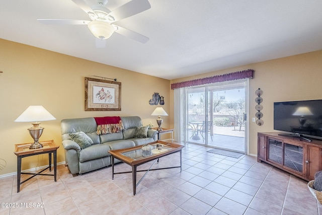 living room with light tile patterned floors, a ceiling fan, and baseboards
