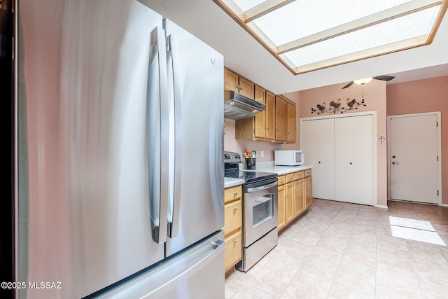 kitchen with under cabinet range hood, appliances with stainless steel finishes, light tile patterned flooring, and light countertops