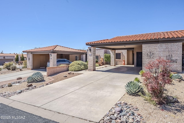mediterranean / spanish-style home with an attached carport, concrete driveway, and a tile roof