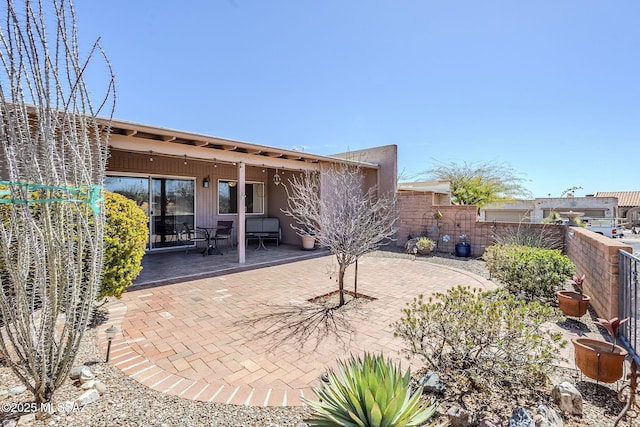 rear view of house with a patio area and a fenced backyard