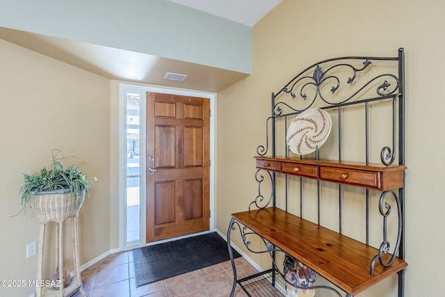 entryway with light tile patterned floors, visible vents, and baseboards