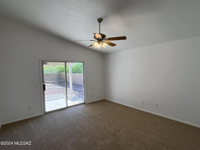 empty room with lofted ceiling, a ceiling fan, a textured ceiling, dark carpet, and baseboards