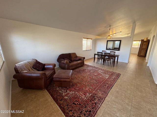 living area featuring light tile patterned flooring and vaulted ceiling