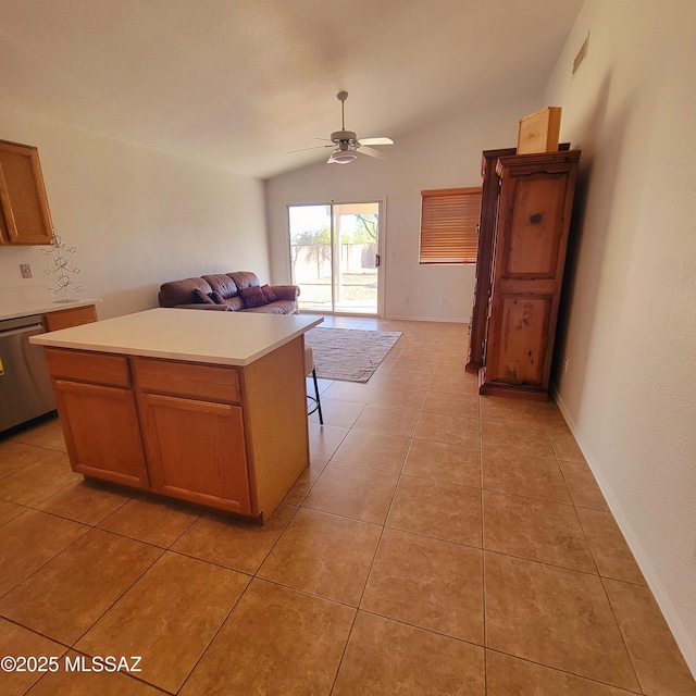 kitchen with dishwasher, light countertops, vaulted ceiling, light tile patterned floors, and a ceiling fan
