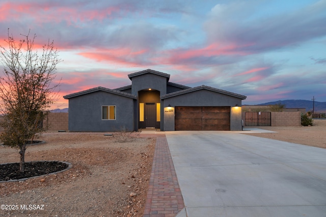 single story home featuring stucco siding, an attached garage, fence, and concrete driveway