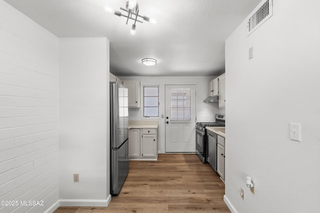 207 S Paseo Tierra Unit A, Green Valley, AZ 85614 - kitchen featuring appliances with stainless steel finishes, light wood-style flooring, under cabinet range hood, and light countertops