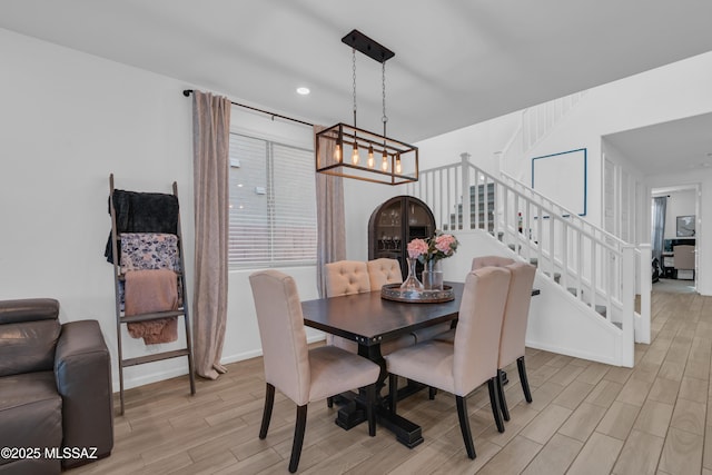 8111 S Soltero Mine Dr, Tucson, AZ 85747 - dining space with light wood finished floors, stairs, a chandelier, and recessed lighting