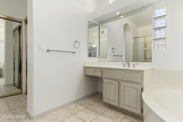 full bath featuring a shower stall, tile patterned floors, baseboards, a bath, and vanity