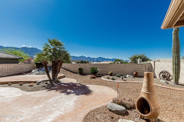 view of yard with a mountain view, a fenced backyard, and a patio area