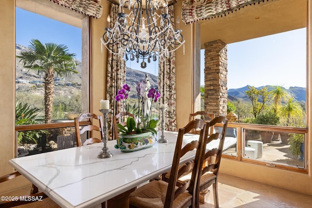 dining space featuring a wealth of natural light, a notable chandelier, and a mountain view