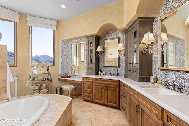 bathroom featuring double vanity, a bath, tasteful backsplash, and a sink