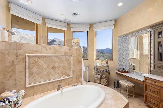 full bathroom featuring a bath, a mountain view, visible vents, and plenty of natural light