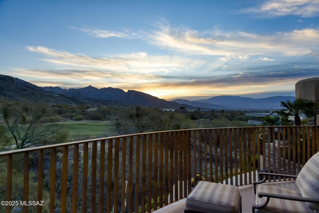 balcony at dusk featuring a mountain view