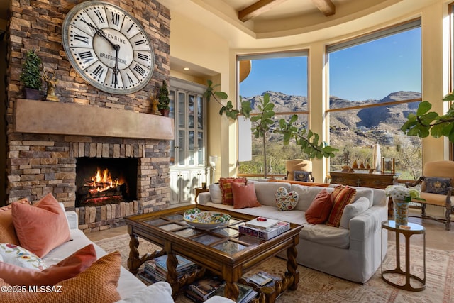 living area with a mountain view, a fireplace, and beamed ceiling