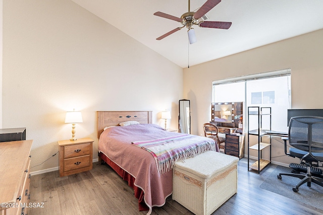 bedroom featuring a ceiling fan, baseboards, lofted ceiling, and wood finished floors