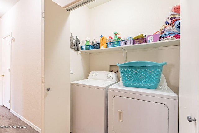 laundry room with washing machine and dryer, laundry area, and light wood-type flooring