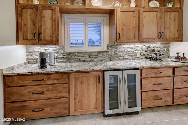 kitchen featuring tasteful backsplash, wine cooler, and light stone countertops