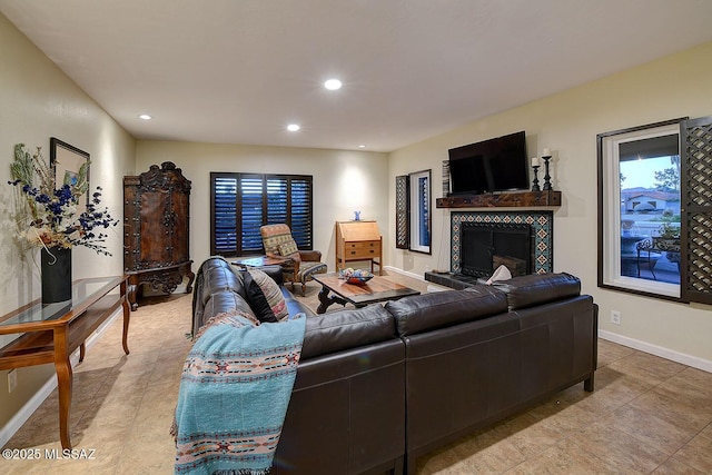 living room featuring baseboards, a fireplace, and recessed lighting