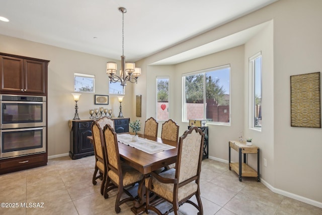dining area featuring light tile patterned floors, baseboards, and a notable chandelier