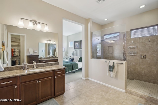 bathroom featuring tile patterned floors, vanity, visible vents, and walk in shower