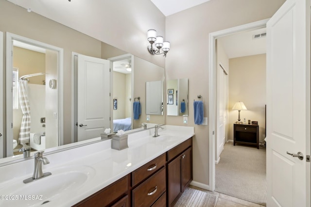 ensuite bathroom featuring double vanity, visible vents, a sink, and connected bathroom