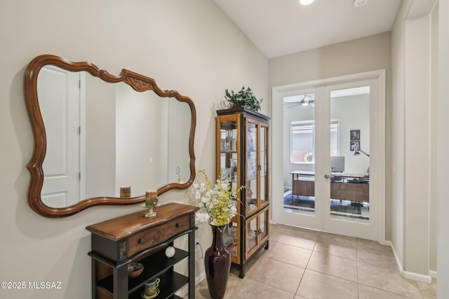 foyer entrance with light tile patterned floors, french doors, baseboards, and a ceiling fan