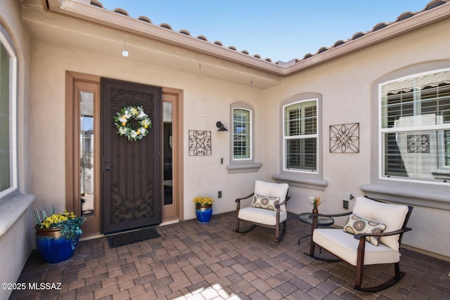 doorway to property featuring a patio and stucco siding