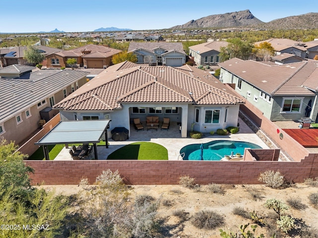 exterior space featuring a mountain view, a fenced backyard, a residential view, and a patio area