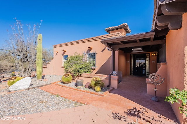 property entrance featuring stucco siding and a tiled roof