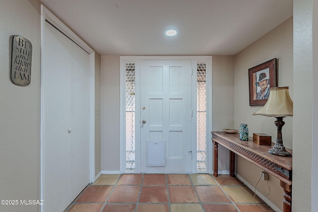 foyer entrance featuring light tile patterned floors and baseboards
