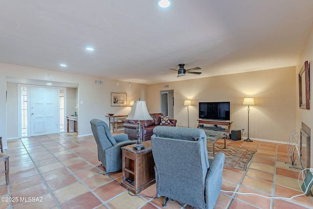 living room featuring baseboards, ceiling fan, and light tile patterned flooring
