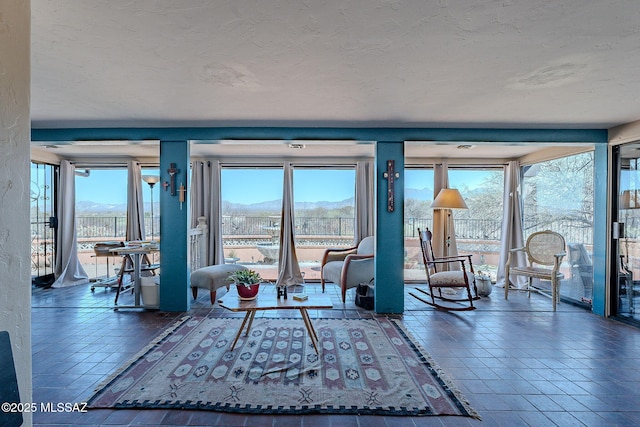 unfurnished living room with a mountain view, a wealth of natural light, and a textured ceiling