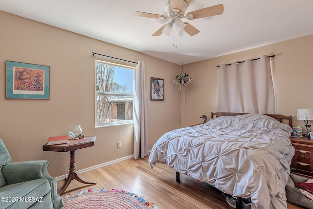 bedroom with light wood-style flooring, baseboards, and ceiling fan