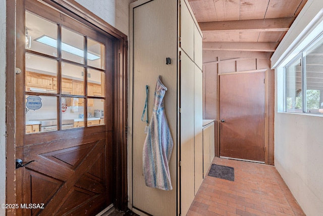 doorway to outside featuring brick floor, beamed ceiling, and wooden ceiling
