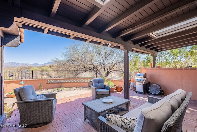 view of patio / terrace with grilling area, an outdoor living space, a mountain view, and a fenced backyard