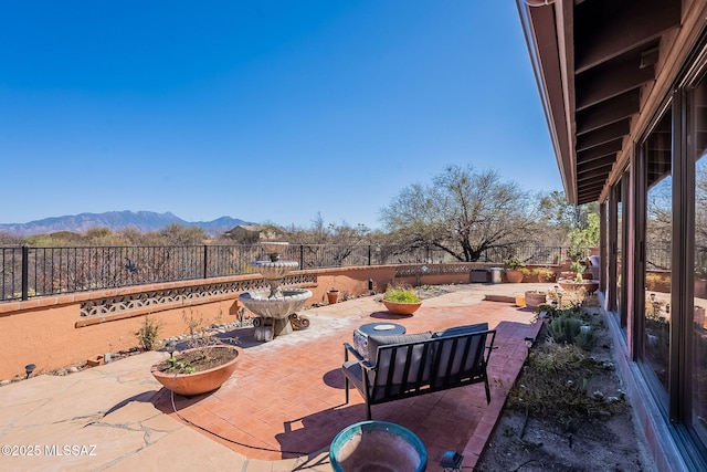 view of patio featuring a mountain view and a fenced backyard