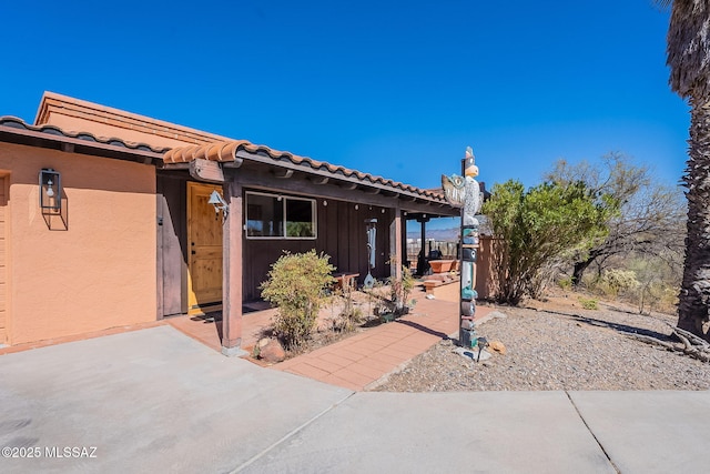 view of property exterior with stucco siding and a tile roof