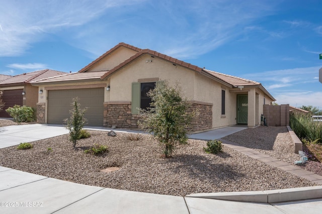 view of front of house with stone siding, a tiled roof, a garage, concrete driveway, and stucco siding