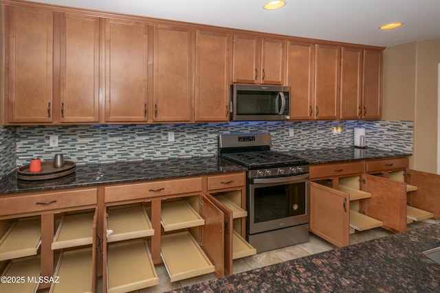 kitchen featuring dark stone counters, stainless steel appliances, recessed lighting, and tasteful backsplash