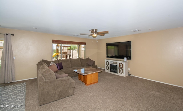living area with baseboards, visible vents, carpet, and a ceiling fan