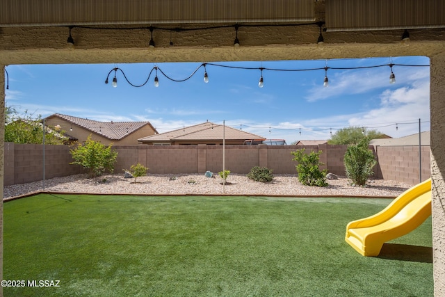 view of yard with a fenced backyard and a playground