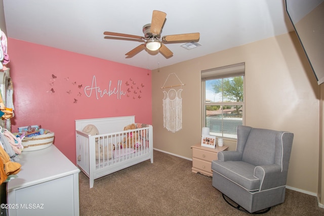 bedroom with a crib, carpet, baseboards, and visible vents