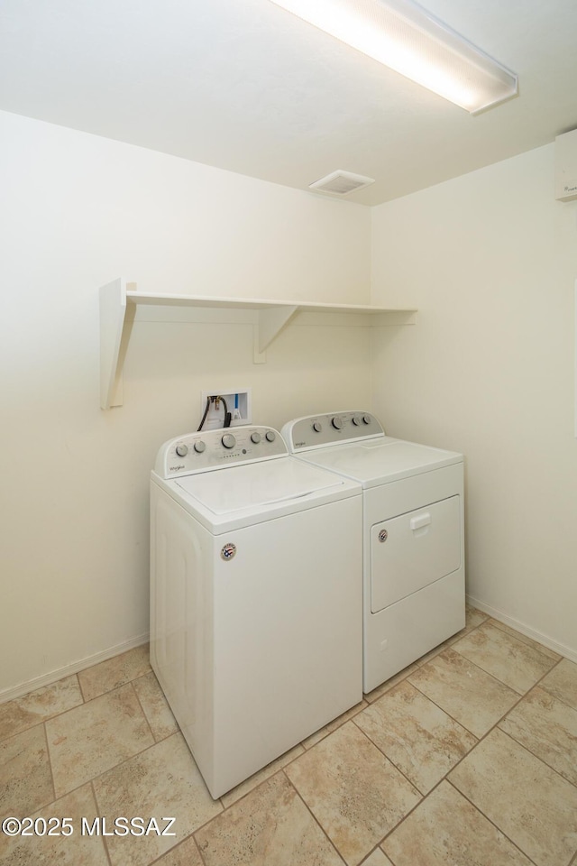 laundry area with washing machine and clothes dryer, baseboards, and laundry area