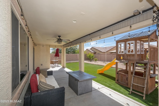 view of patio / terrace with a fenced backyard, a playground, and ceiling fan